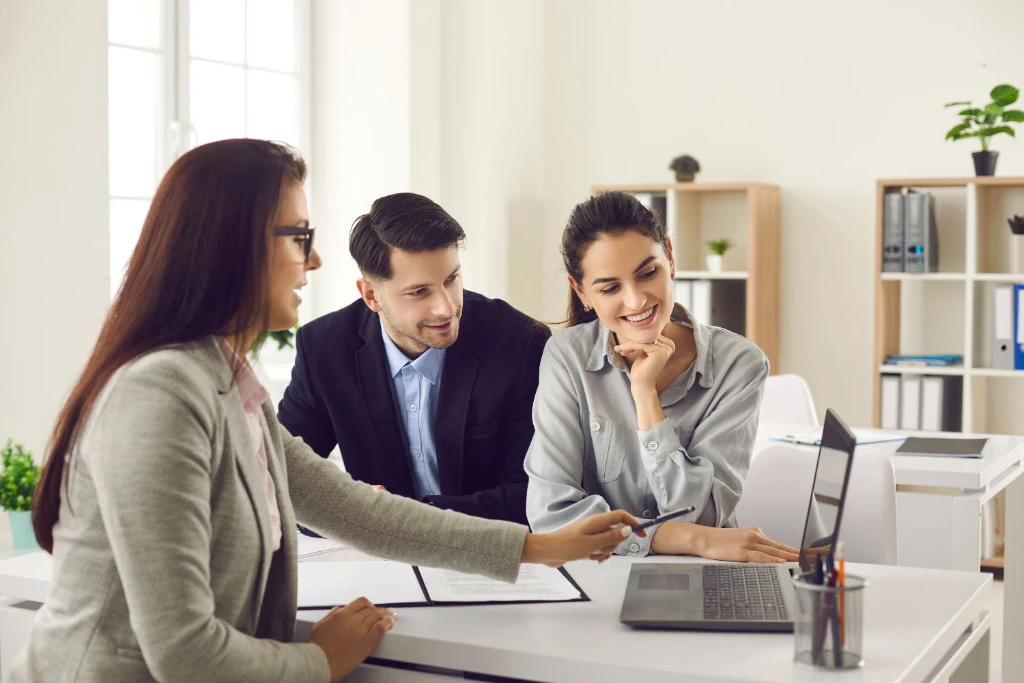 Image of agent showing a couple something on a laptop