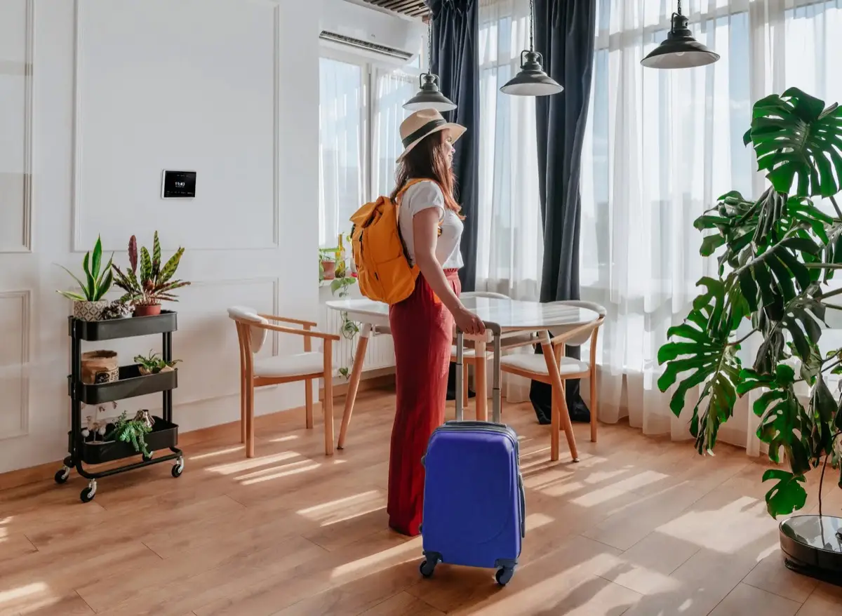 A guest arriving with a suitcase at a bright holiday apartment