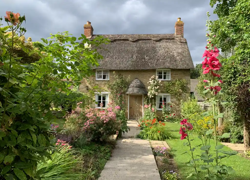 A traditional stone holiday cottage with a flower filled garden