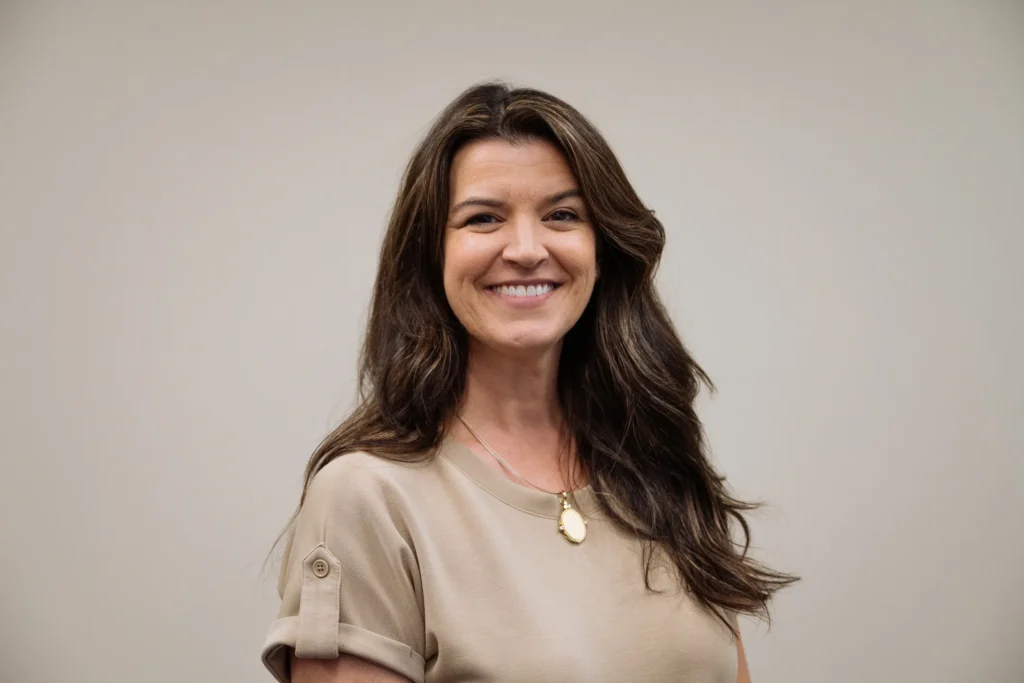 Portrait of smiling woman standing in a neutral office setting