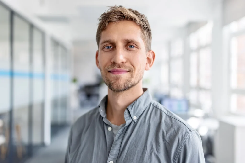 Portrait of a smiling man standing in an office environment
