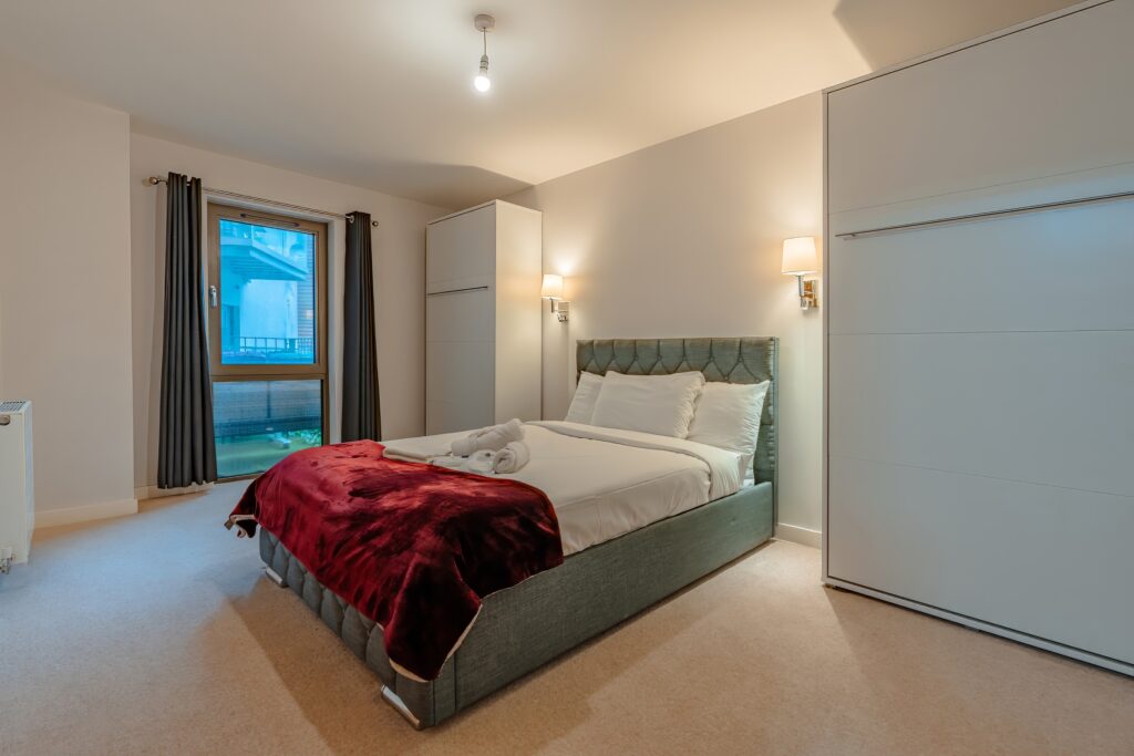 Bedroom with double bed, throw blanket, and soft lighting