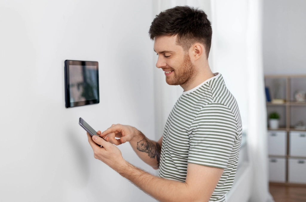 Man setting up a wall-mounted device in a modern flat